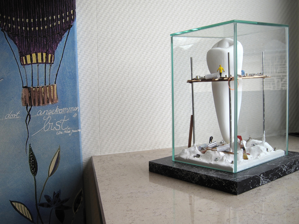 Detailfoto des Kunstobjektes eines Zahns in einer Glasvitrine.